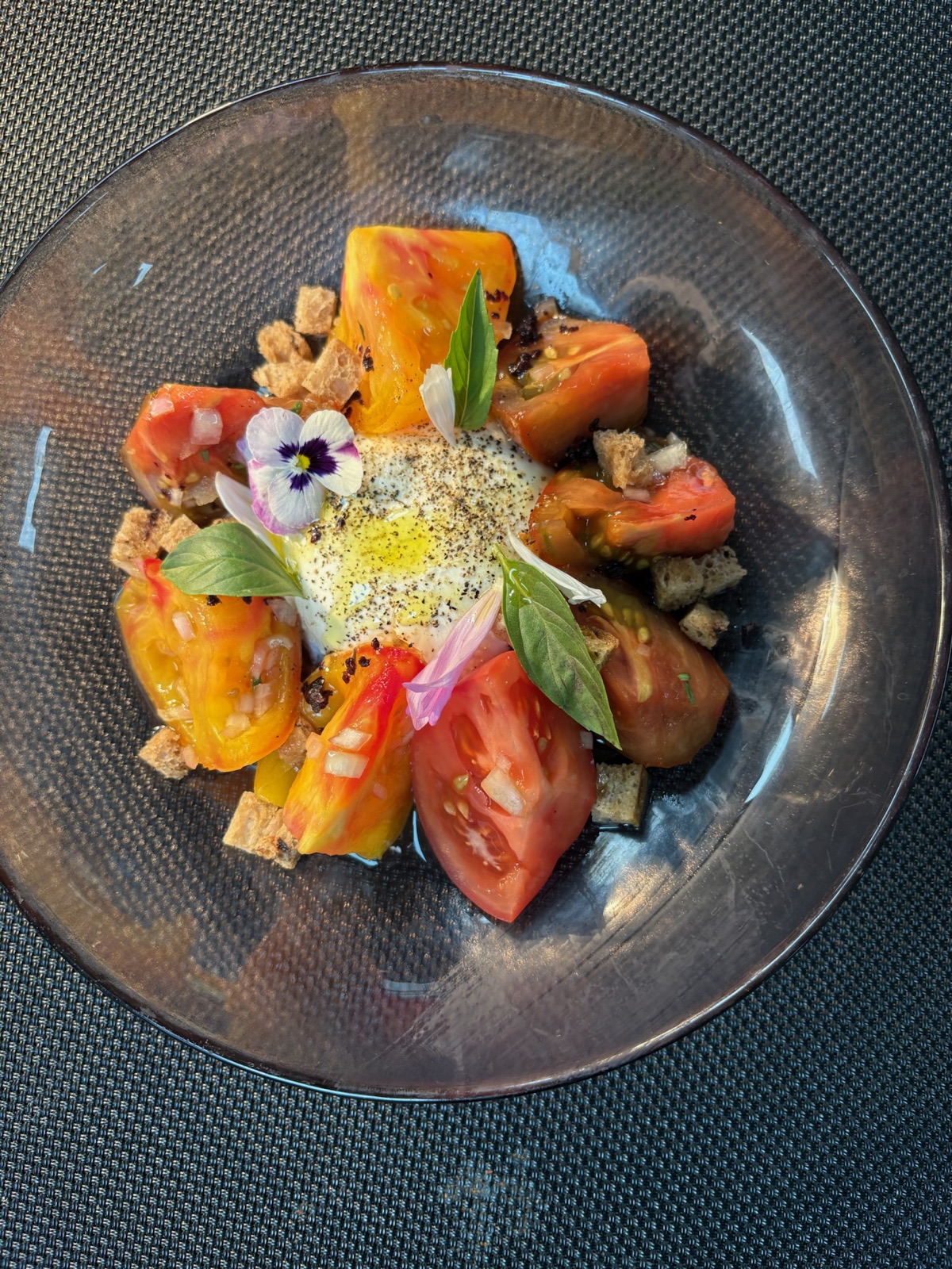 Heirloom tomatoes, a soft egg, basil, and blossoms